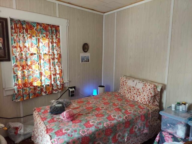 bedroom featuring wood walls