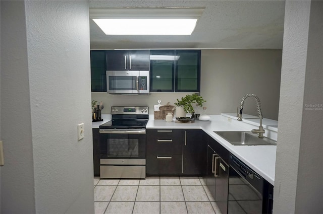 kitchen with light tile patterned floors, stainless steel appliances, and sink