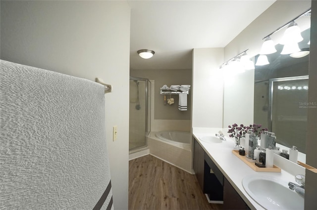 bathroom with vanity, hardwood / wood-style floors, and plus walk in shower