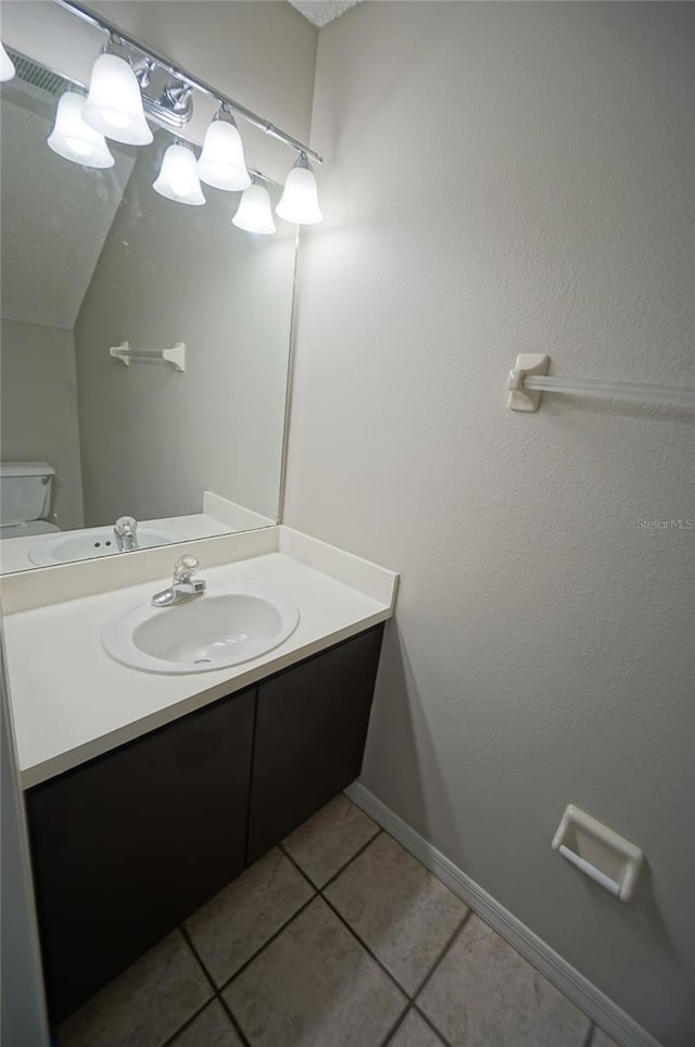 bathroom featuring tile patterned flooring, vanity, and toilet