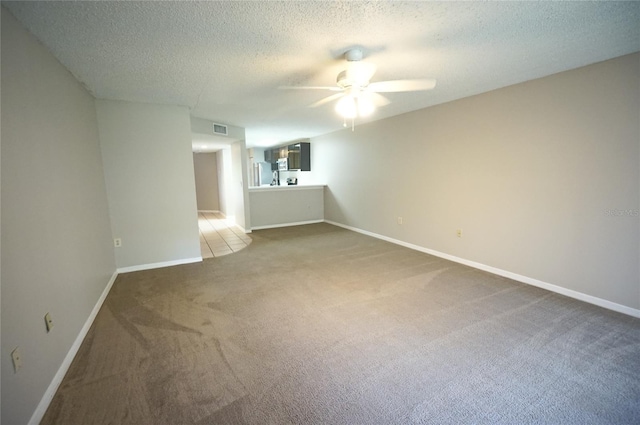 carpeted empty room featuring a textured ceiling and ceiling fan