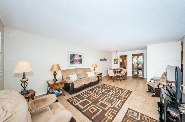 living room with a textured ceiling and light tile patterned floors