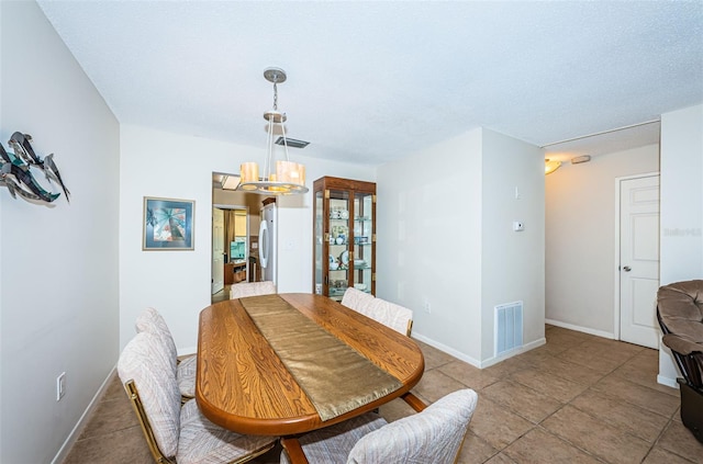 tiled dining room featuring a notable chandelier