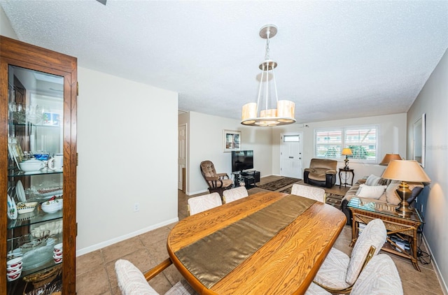 dining space featuring light tile patterned flooring, a textured ceiling, baseboards, and an inviting chandelier