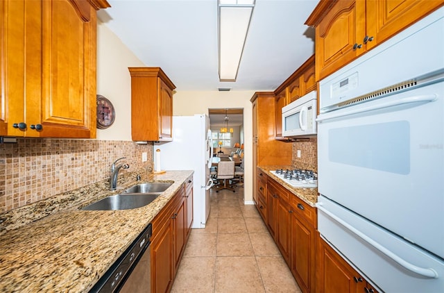 kitchen featuring light tile patterned floors, white appliances, sink, and backsplash