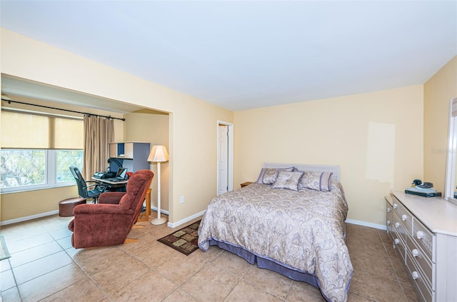 bedroom featuring light tile patterned floors and baseboards