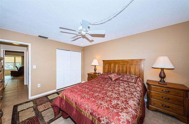 bedroom with a closet, a textured ceiling, light tile patterned floors, and ceiling fan