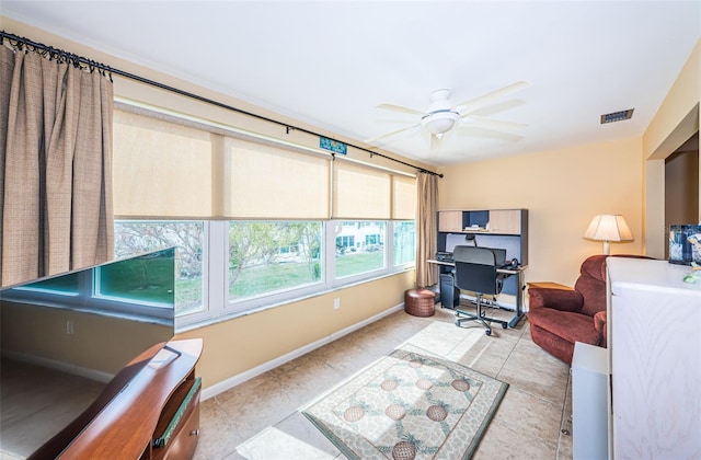 home office with light tile patterned floors, ceiling fan, visible vents, and baseboards