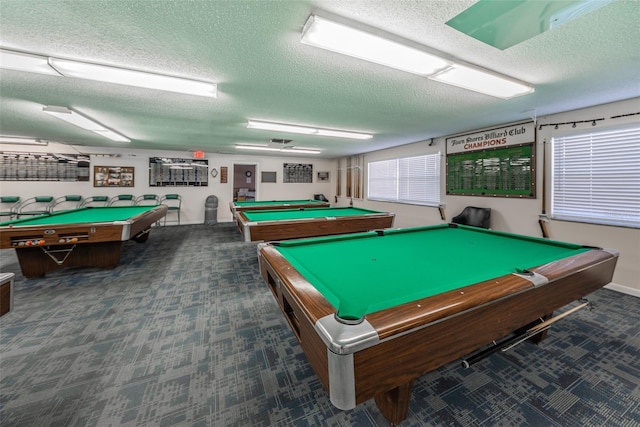 game room featuring billiards, dark carpet, and a textured ceiling