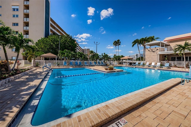 pool with a patio area and fence