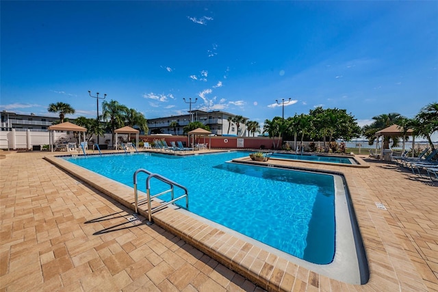 community pool featuring fence, a gazebo, and a patio