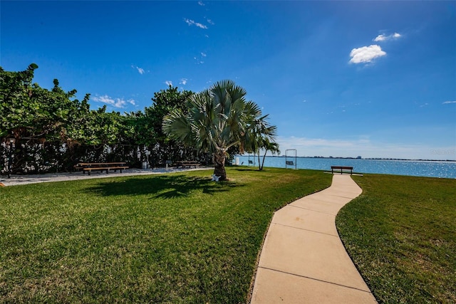 view of home's community with a water view and a yard