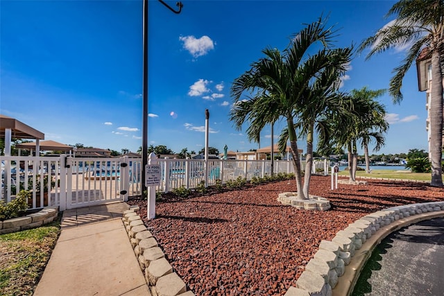 view of property's community featuring a swimming pool, a water view, and fence