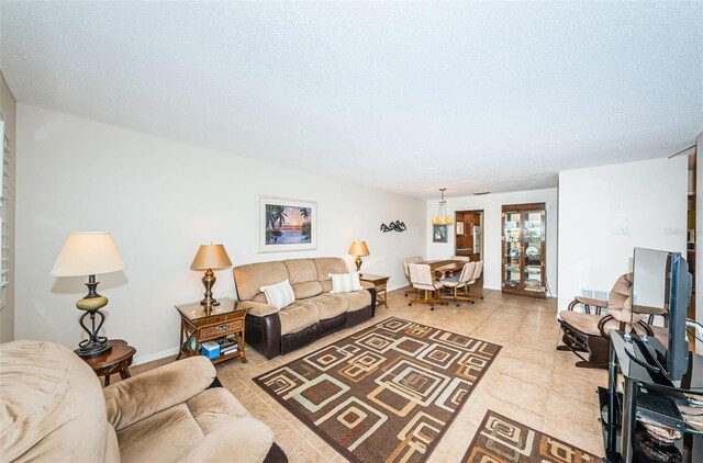 living room featuring light tile patterned floors, a textured ceiling, and baseboards