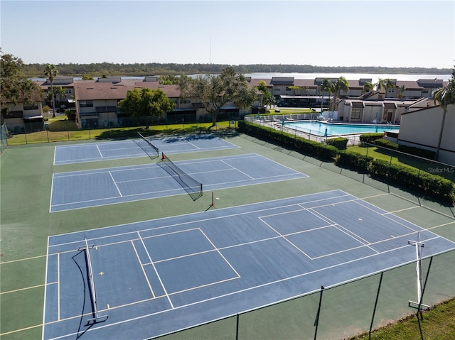 view of tennis court with a community pool