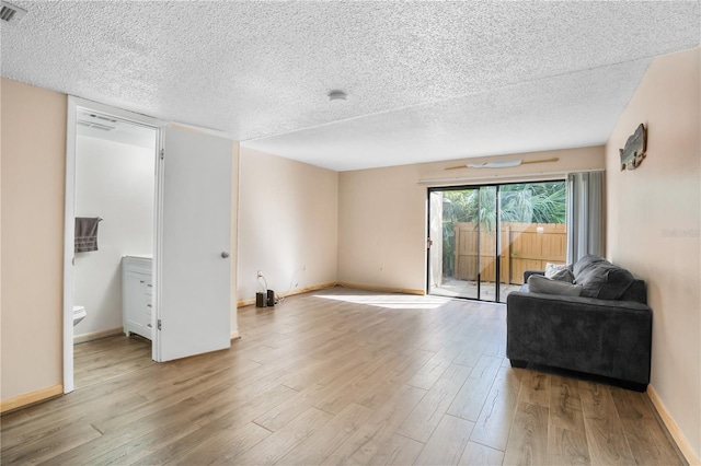 living room featuring a textured ceiling and light hardwood / wood-style flooring