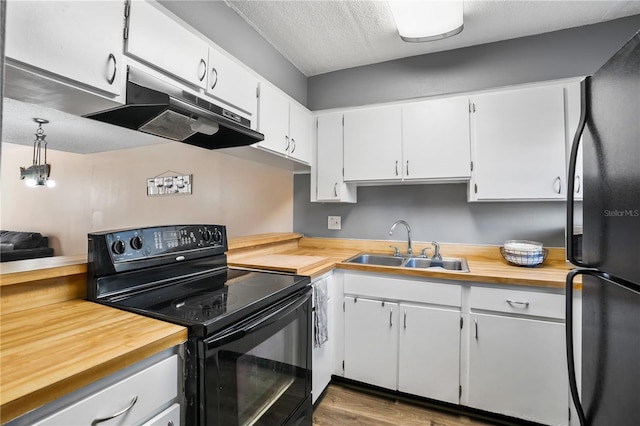 kitchen featuring white cabinetry, sink, black appliances, a textured ceiling, and hardwood / wood-style floors