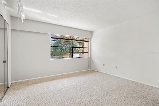 empty room featuring a textured ceiling and carpet