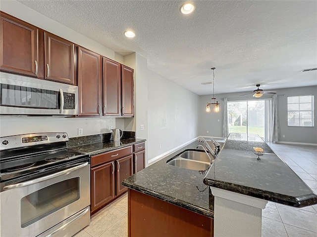 kitchen featuring appliances with stainless steel finishes, hanging light fixtures, sink, and light tile patterned floors