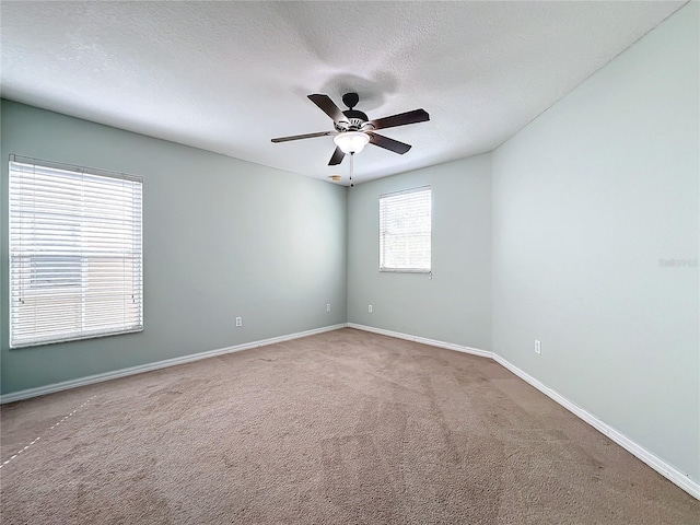 carpeted spare room featuring ceiling fan and a textured ceiling