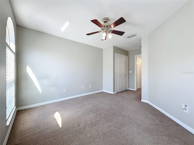 unfurnished bedroom with carpet flooring, multiple windows, ceiling fan, and a closet