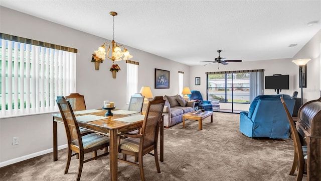 dining room featuring ceiling fan with notable chandelier, a textured ceiling, and dark carpet