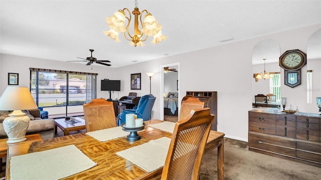 dining space featuring ceiling fan with notable chandelier and carpet flooring