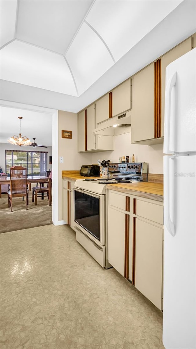 kitchen with white appliances, cream cabinetry, wood counters, and an inviting chandelier