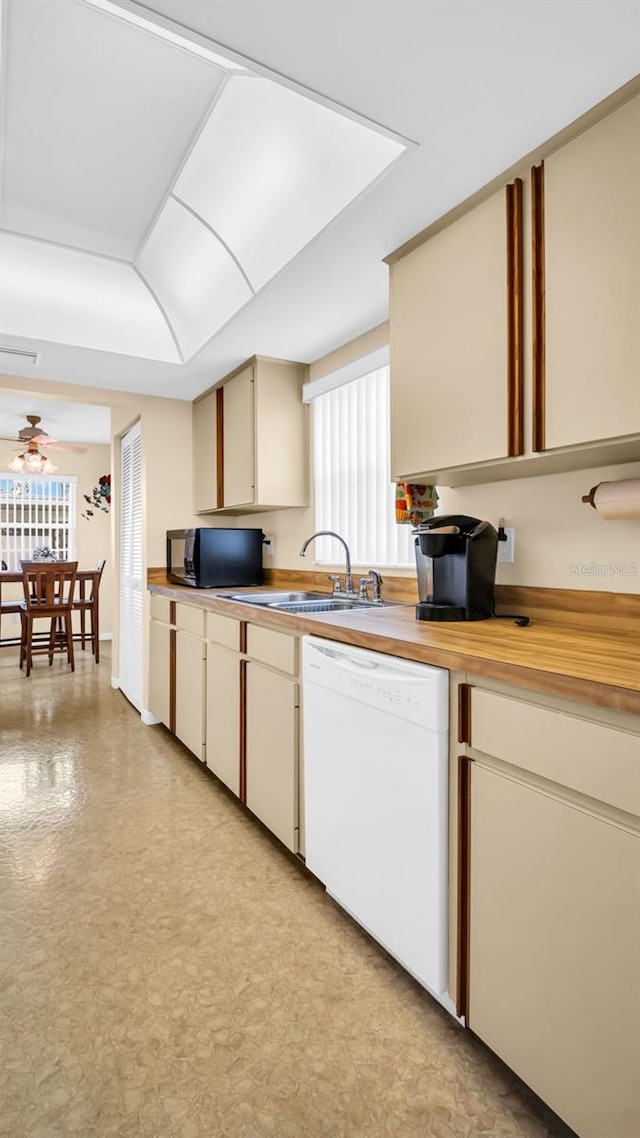 kitchen featuring ceiling fan, sink, dishwasher, and cream cabinetry