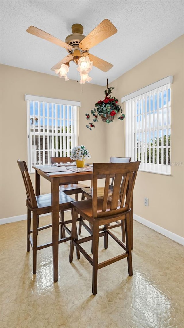 dining room with a textured ceiling and ceiling fan