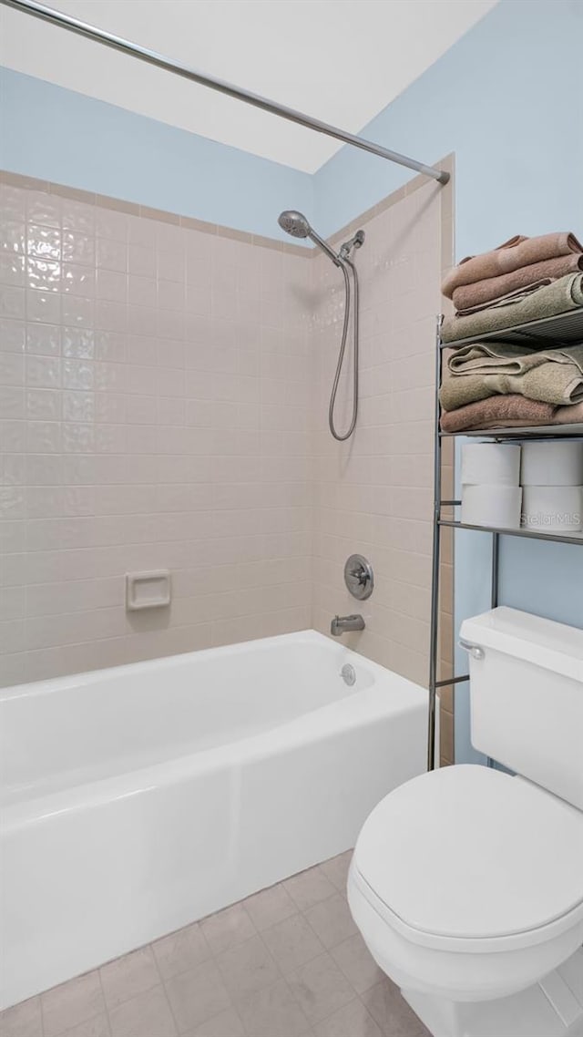 bathroom featuring tiled shower / bath and toilet