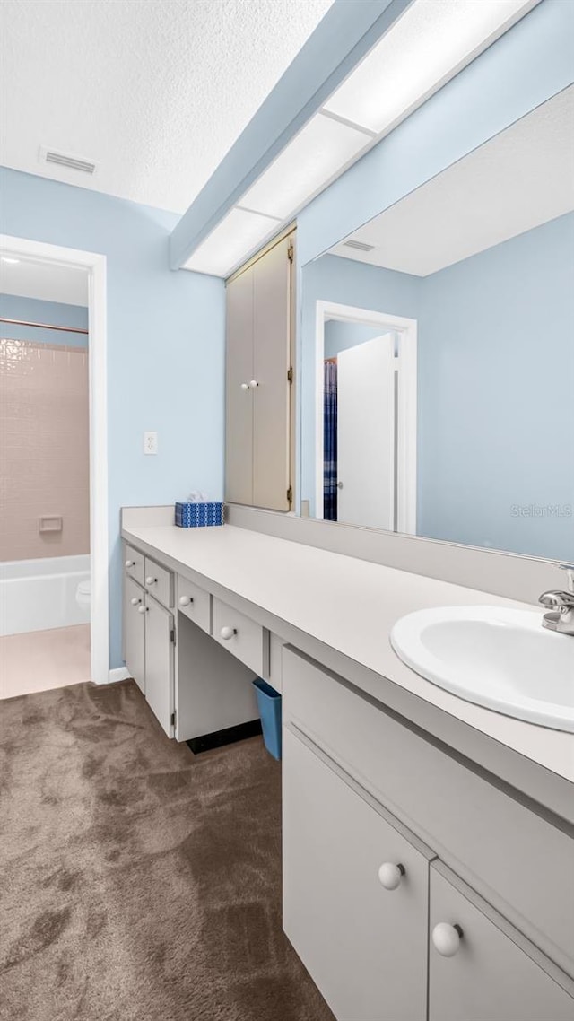 bathroom with vanity, a textured ceiling, and shower / bathtub combination