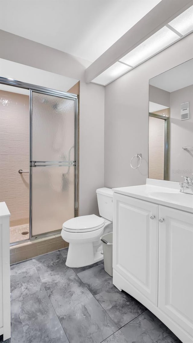 bathroom featuring an enclosed shower, vanity, and toilet