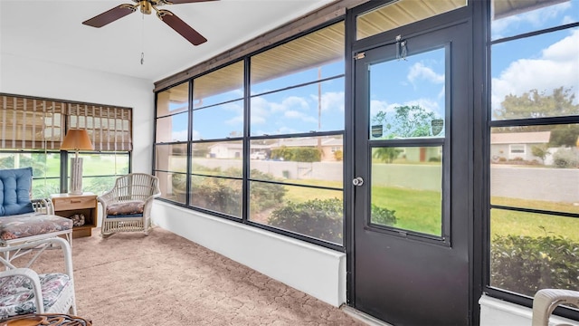 sunroom / solarium featuring a healthy amount of sunlight and ceiling fan