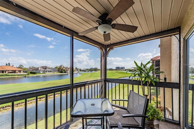 balcony with a water view and ceiling fan