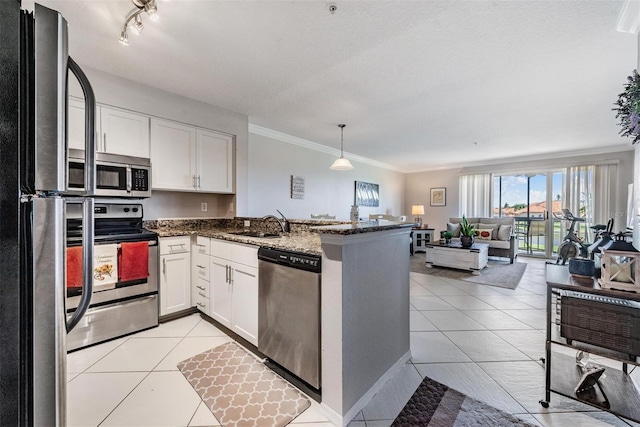 kitchen with kitchen peninsula, appliances with stainless steel finishes, dark stone counters, pendant lighting, and white cabinetry