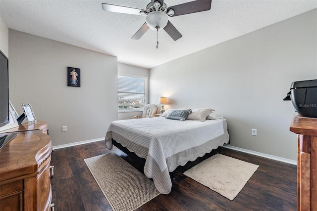 bedroom with a textured ceiling, ceiling fan, and dark wood-type flooring