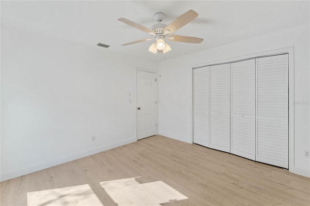 unfurnished bedroom featuring ceiling fan, a closet, and light hardwood / wood-style flooring