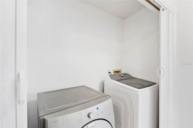 washroom featuring separate washer and dryer and a textured ceiling