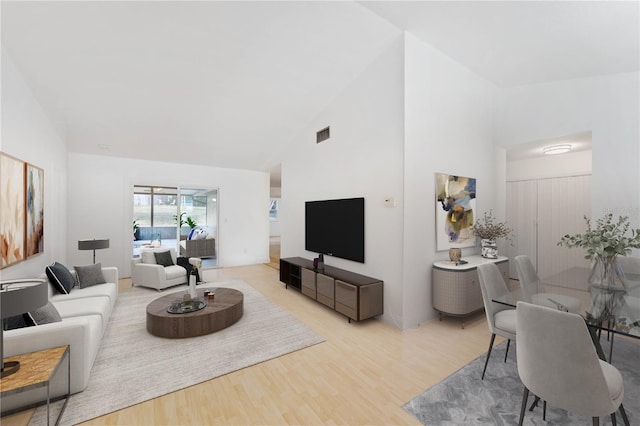 living room featuring light hardwood / wood-style floors and high vaulted ceiling