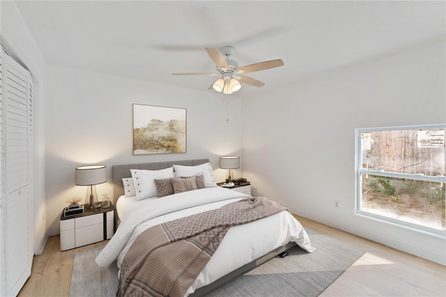 bedroom featuring light hardwood / wood-style floors, ceiling fan, and a closet