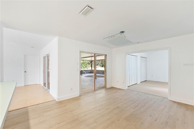 unfurnished room featuring light hardwood / wood-style flooring and lofted ceiling