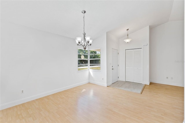 interior space with light hardwood / wood-style floors, lofted ceiling, and a notable chandelier