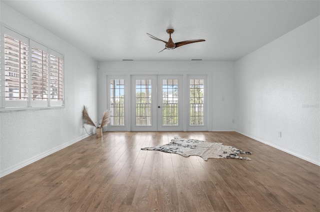 spare room featuring hardwood / wood-style flooring, ceiling fan, and french doors