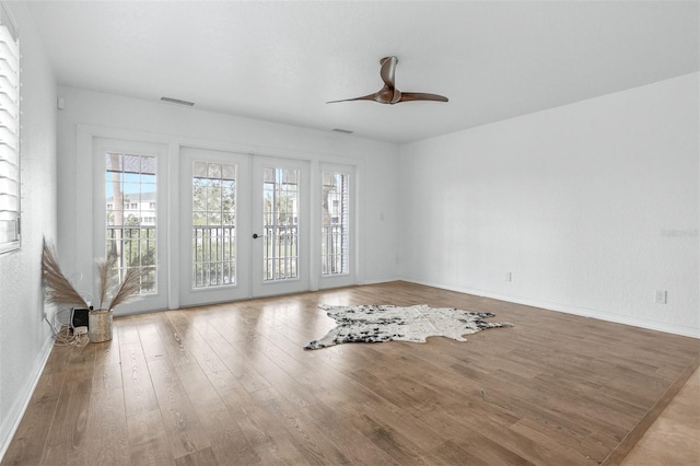 spare room featuring ceiling fan, wood-type flooring, and french doors