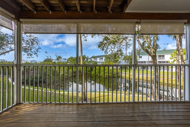 unfurnished sunroom with a water view and beam ceiling