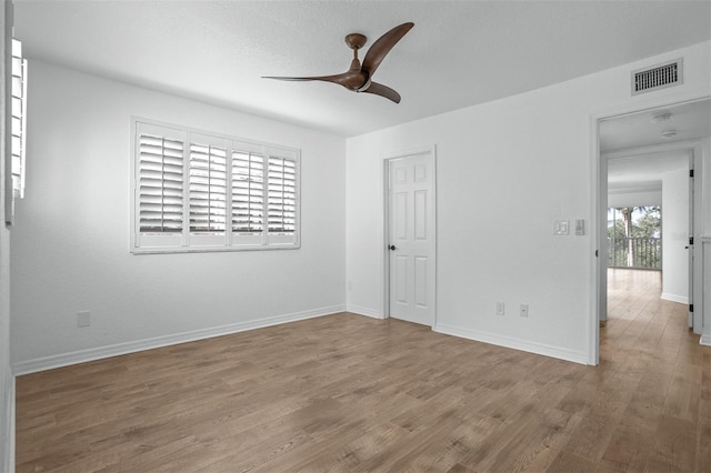 empty room with hardwood / wood-style floors and ceiling fan