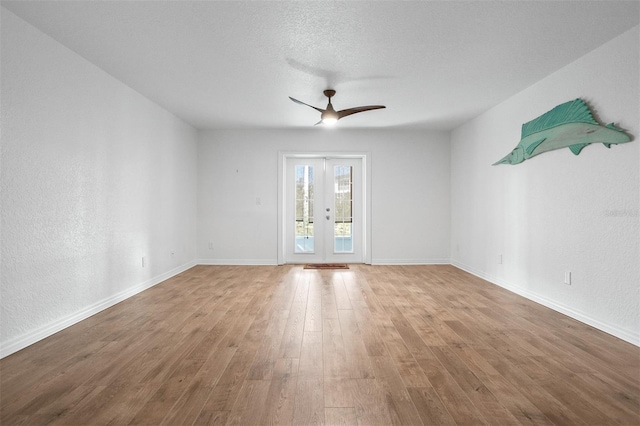 spare room with french doors, light wood-type flooring, a textured ceiling, and ceiling fan