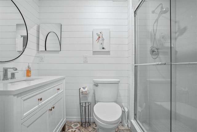 bathroom featuring vanity, wooden walls, toilet, and a shower with door