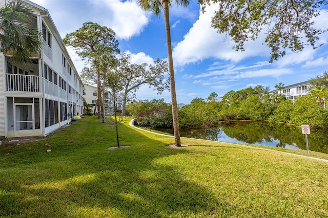 view of yard featuring a water view and a sunroom